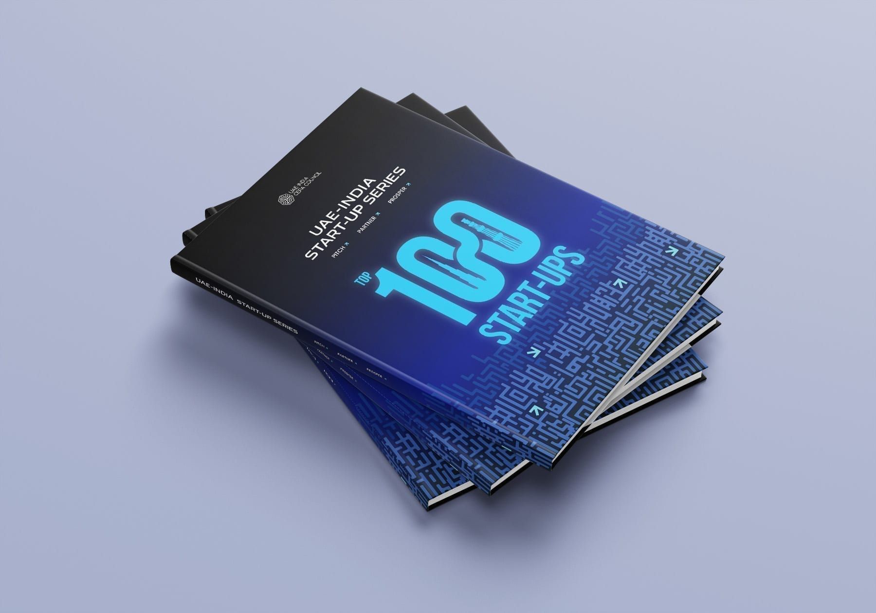 Three copies of the UAE–India Start-up Series dossier stacked at an angle. The dark blue cover reads “Top 100 Start-ups” over a maze pattern.